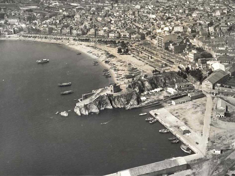 Vista aèria del passeig i la platja amb la punta dels Guíxols en primer terme, 1965 AMSFG. Col·lecció Municipal d’Imatges (Autor: Paisajes Españoles Fotografías Aéreas)