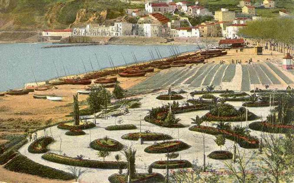 Platja amb barques de pesca i xarxes esteses, al centre, el cobert de les drassanes. Principis del segle XX. AMSFG. Col·lecció Municipal d’Imatges (Autor desconegut).