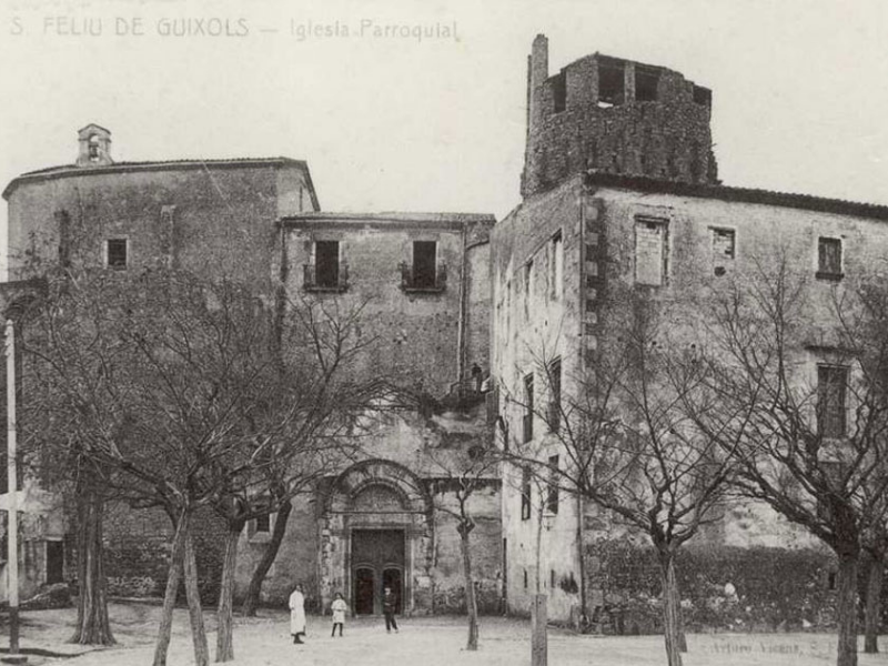 Vista de la plaça del Monestir i l’església parroquial de Nostra Senyora dels Àngels de Sant Feliu de Guíxols a principis del segle XX. AMSFG. Col·lecció Municipal d’Imatges (Autor desconegut).