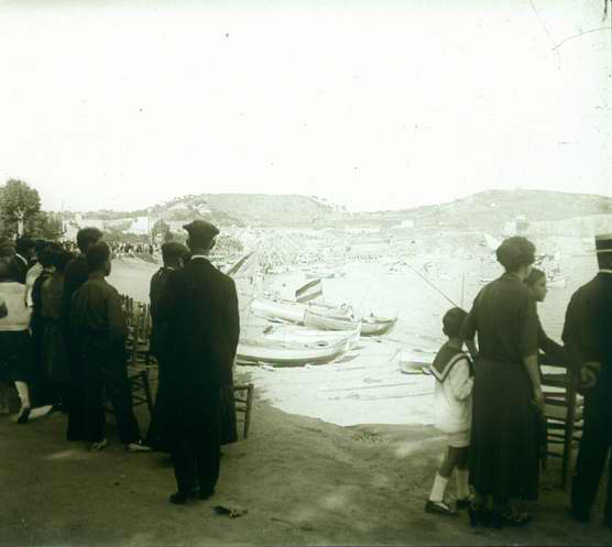 Platja de Sant Feliu de Guíxols plena de gent observant com salpen les barques engalanades AMSFG. Fons Francesc Llorens (Autor: Francesc Llorens)